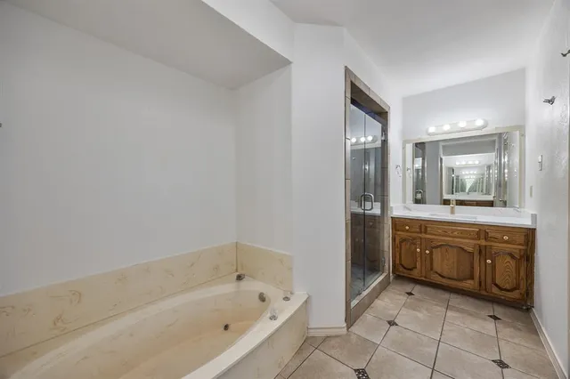 a spacious bathroom with a bathtub sink and mirror