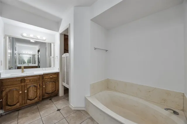 a bathroom with a bathtub sink and mirror