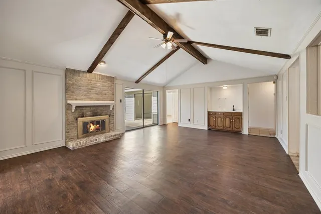 a view of empty room with wooden floor fireplace and windows
