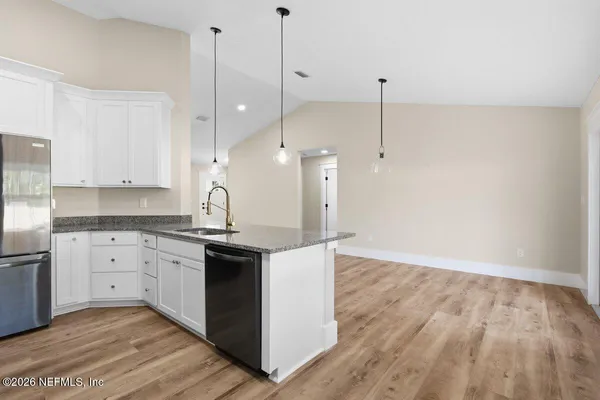 a large kitchen with kitchen island white cabinets and wooden floor
