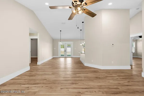 a view of a room with a ceiling fan window and wooden floor