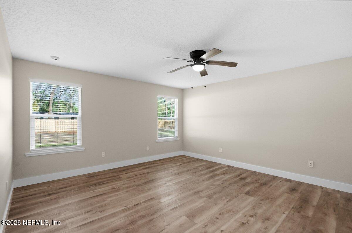 6093 Taylor Road Jacksonville, FL 32234 - Photo 16 of 44 a view of an empty room with a window and wooden floor