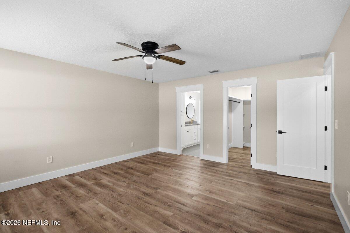 6093 Taylor Road Jacksonville, FL 32234 - Photo 17 of 44 a view of empty room with wooden floor and ceiling fan