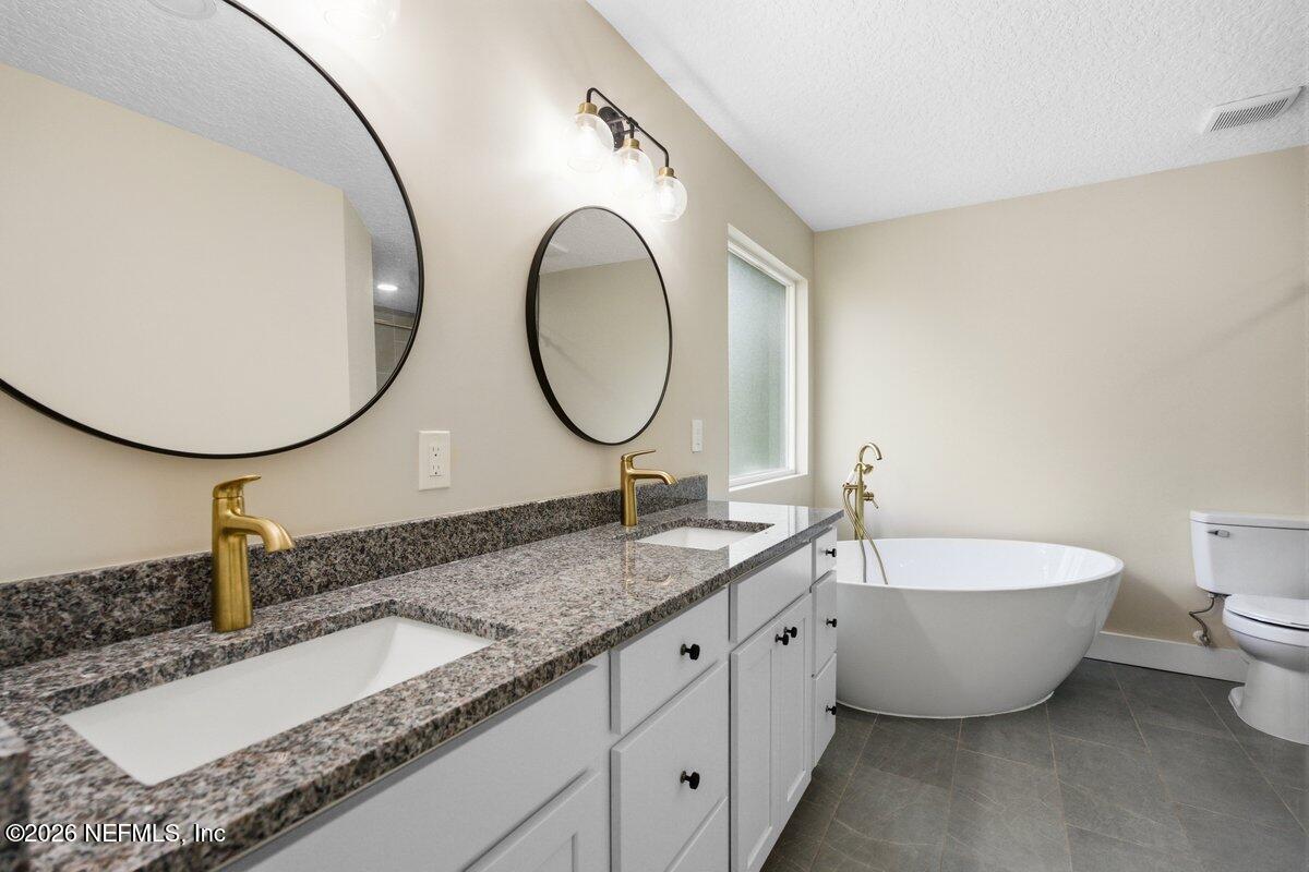 6093 Taylor Road Jacksonville, FL 32234 - Photo 21 of 44 a bathroom with a granite countertop double vanity sink and a mirror