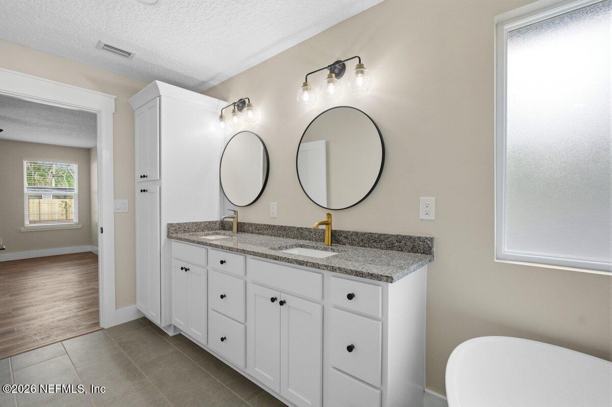 6093 Taylor Road Jacksonville, FL 32234 - Photo 22 of 44 a bathroom with a granite countertop double vanity sink and a mirror