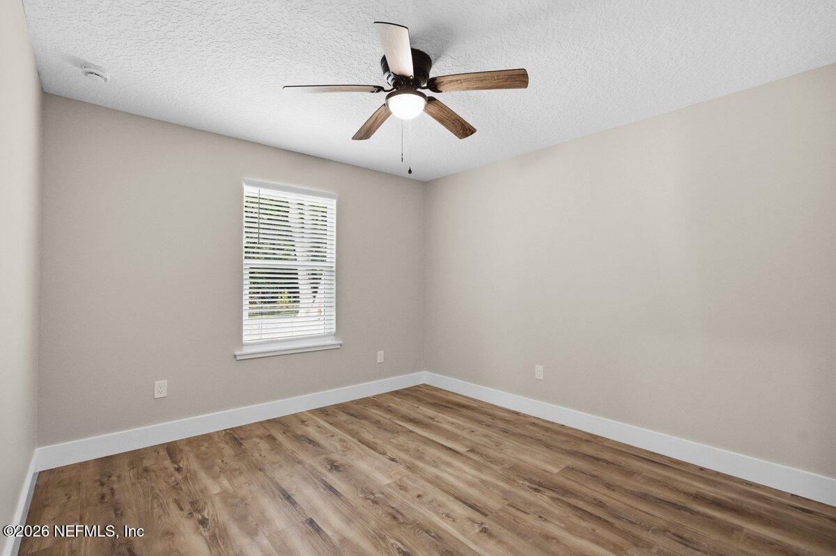 6093 Taylor Road Jacksonville, FL 32234 - Photo 25 of 44 an empty room with wooden floor and windows