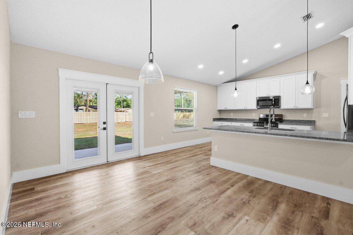 6093 Taylor Road Jacksonville, FL 32234 - Photo 8 of 44 a view of kitchen with stainless steel appliances granite countertop wooden floors refrigerator and window