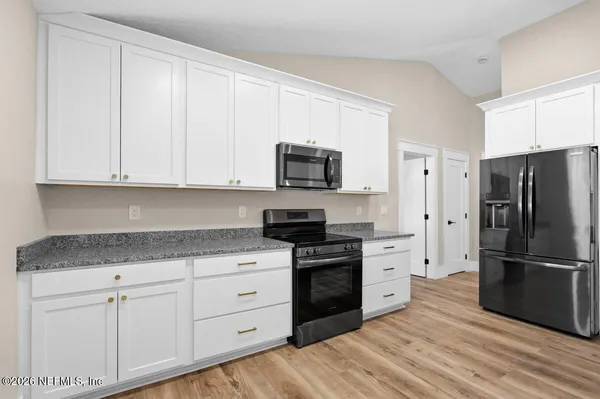 a kitchen with kitchen island a sink stainless steel appliances and cabinets