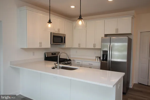 a kitchen with a refrigerator a microwave a stove and cabinets