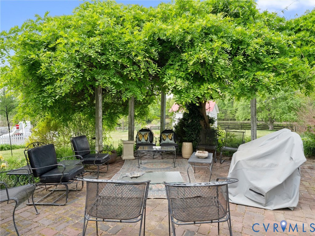 2625 Old Tavern Road Powhatan, VA 23139 - Photo 86 of 100 a view of a patio with table and chairs potted plants and a large tree