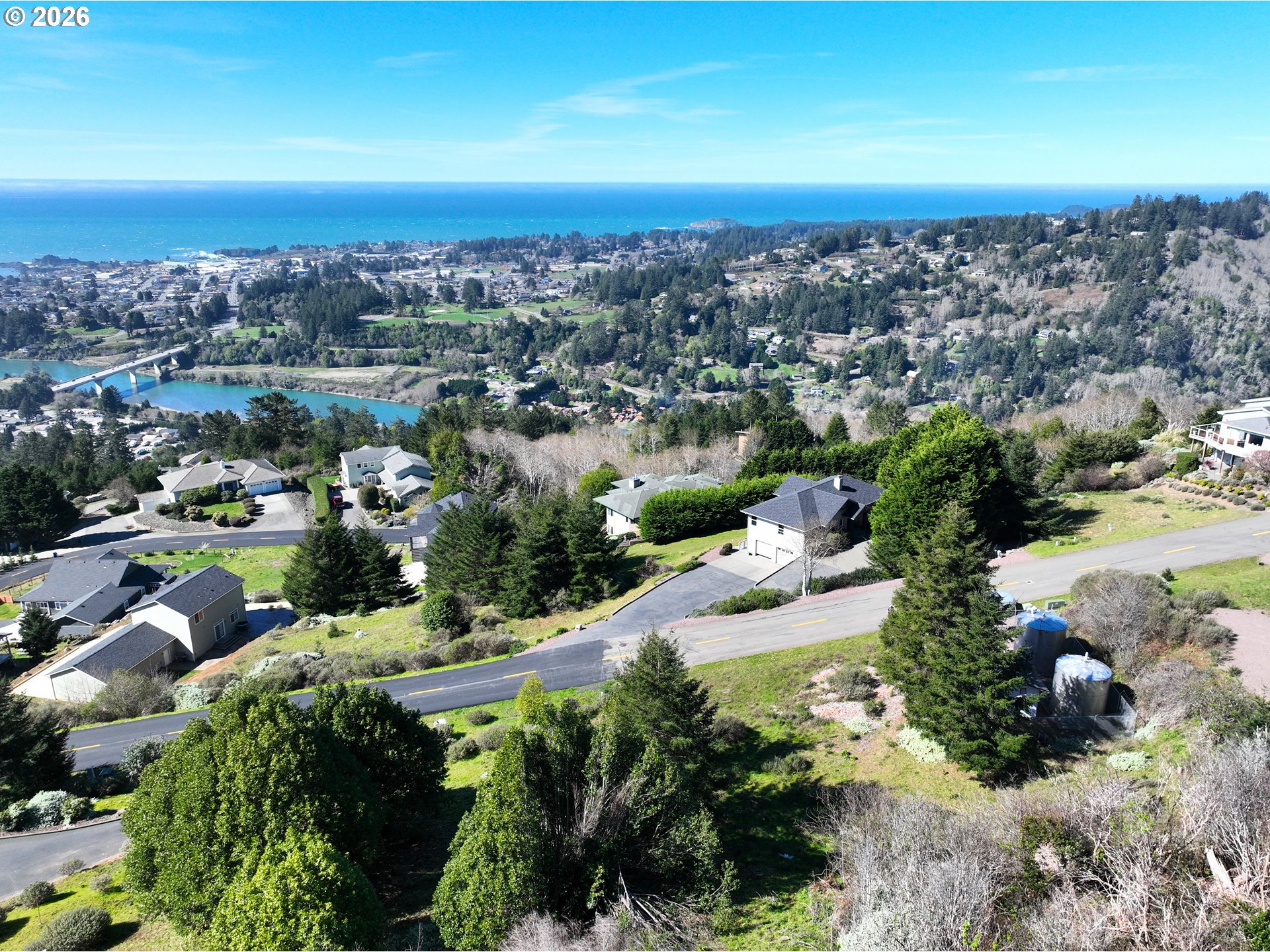 98007 Crown Terrace, Unit 7 Brookings, OR 97415 - Photo 2 of 18 an aerial view of a city with lots of residential buildings and mountain view in back