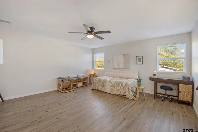 a spacious bedroom with a bed a table and a window