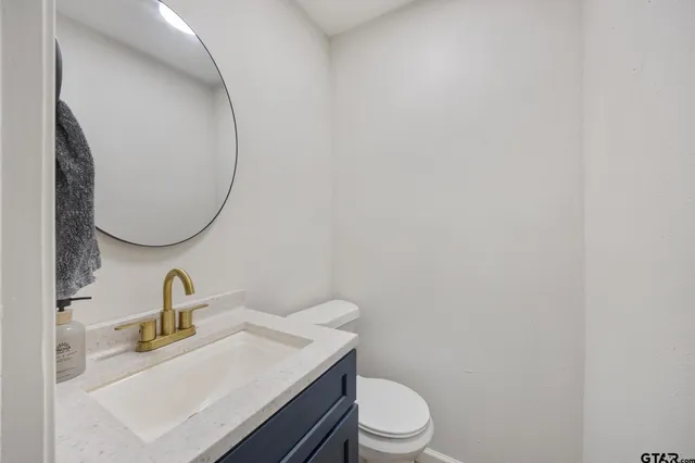 a bathroom with a sink a toilet and a mirror