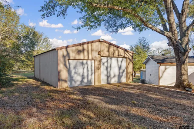a view of a house with a large tree and wooden fence