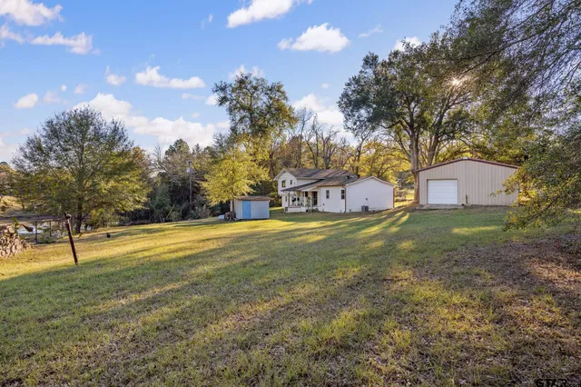 a house view with swimming pool and trees in the background