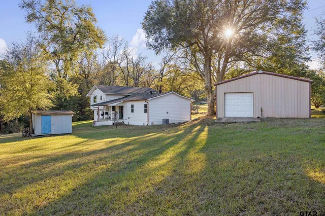 a front view of house with yard and trees in the background