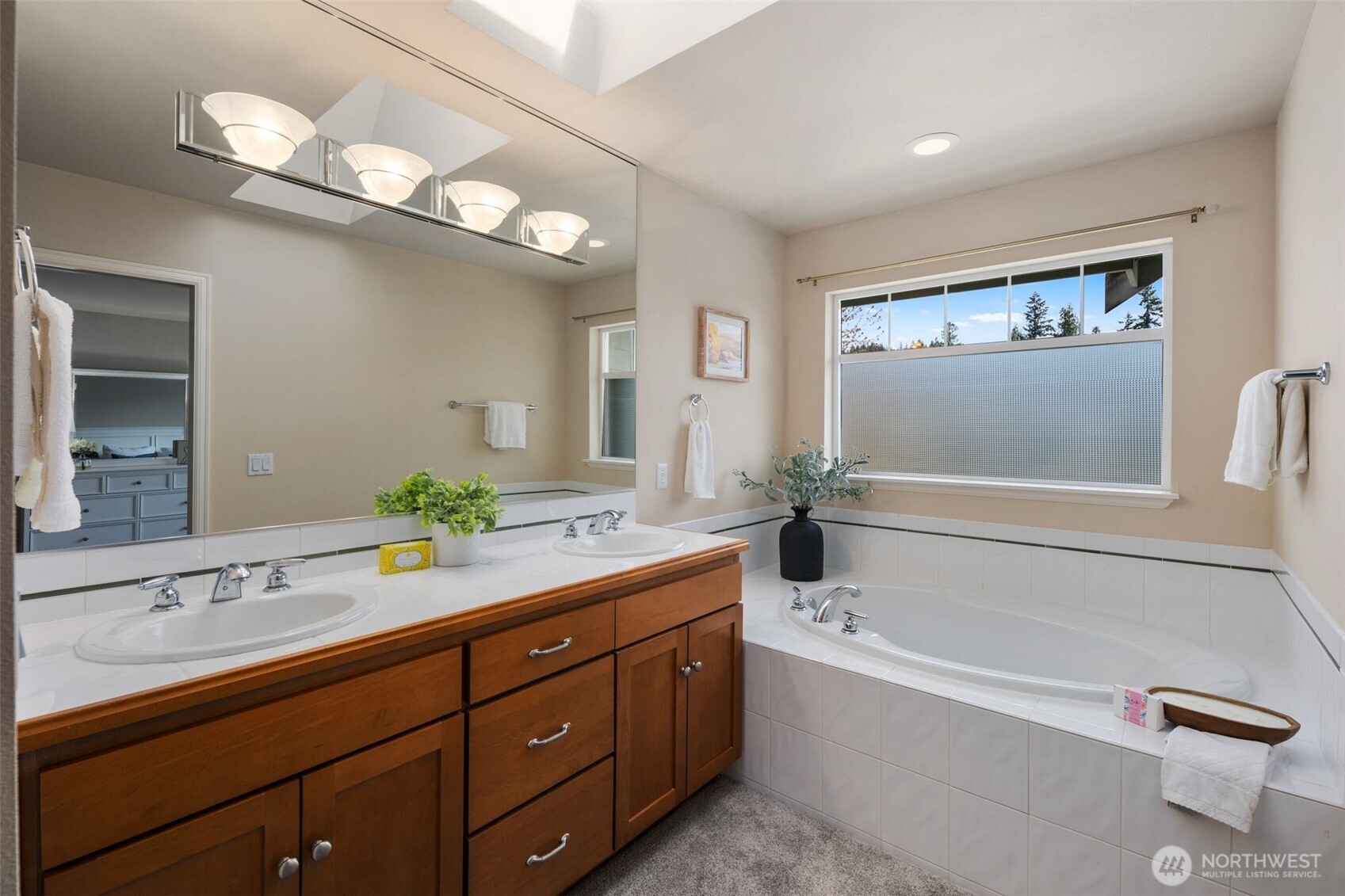 18523 173rd Street Southeast Renton, WA 98058 - Photo 23 of 40 a bathroom with a tub a double vanity sink and a mirror