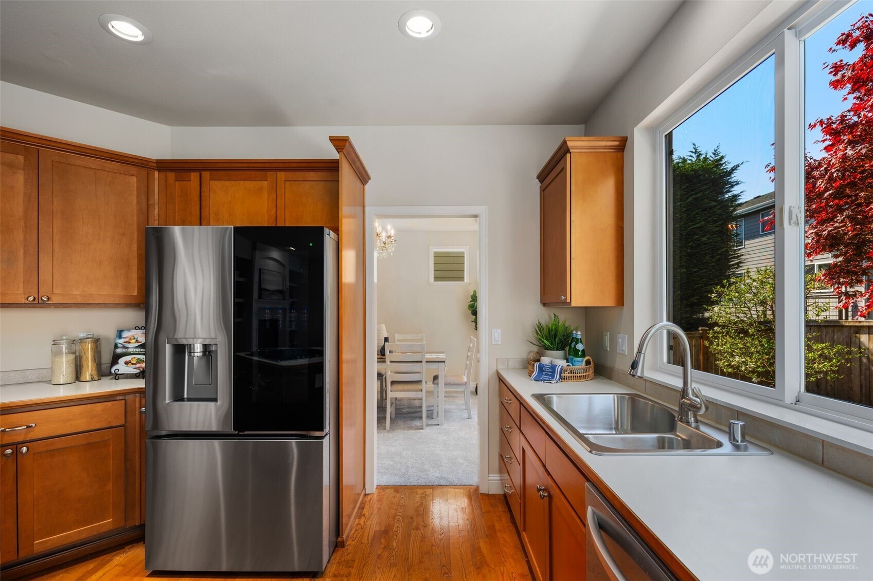 18523 173rd Street Southeast Renton, WA 98058 - Photo 10 of 40 a kitchen with a refrigerator a stove a sink dishwasher and wooden cabinets with wooden floor