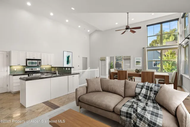 a living room with stainless steel appliances kitchen island granite countertop a couch and a view of kitchen living room