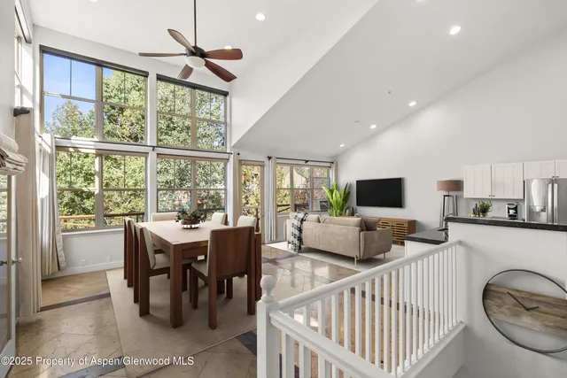 a living room with furniture a flat screen tv and a large window