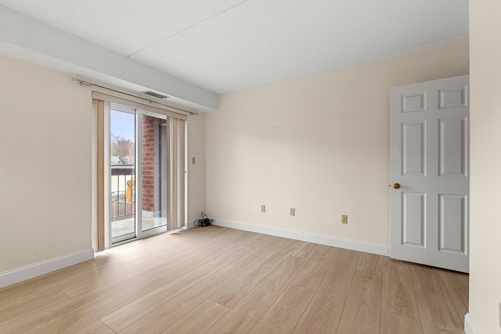159 Main Street, Unit 11B Melrose, MA 02176 - Photo 22 of 33 an empty room with wooden floor