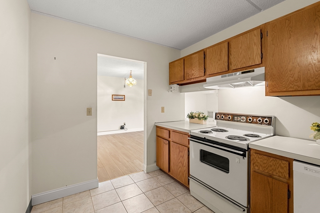 159 Main Street, Unit 11B Melrose, MA 02176 - Photo 24 of 33 a kitchen with stainless steel appliances granite countertop a stove and a refrigerator