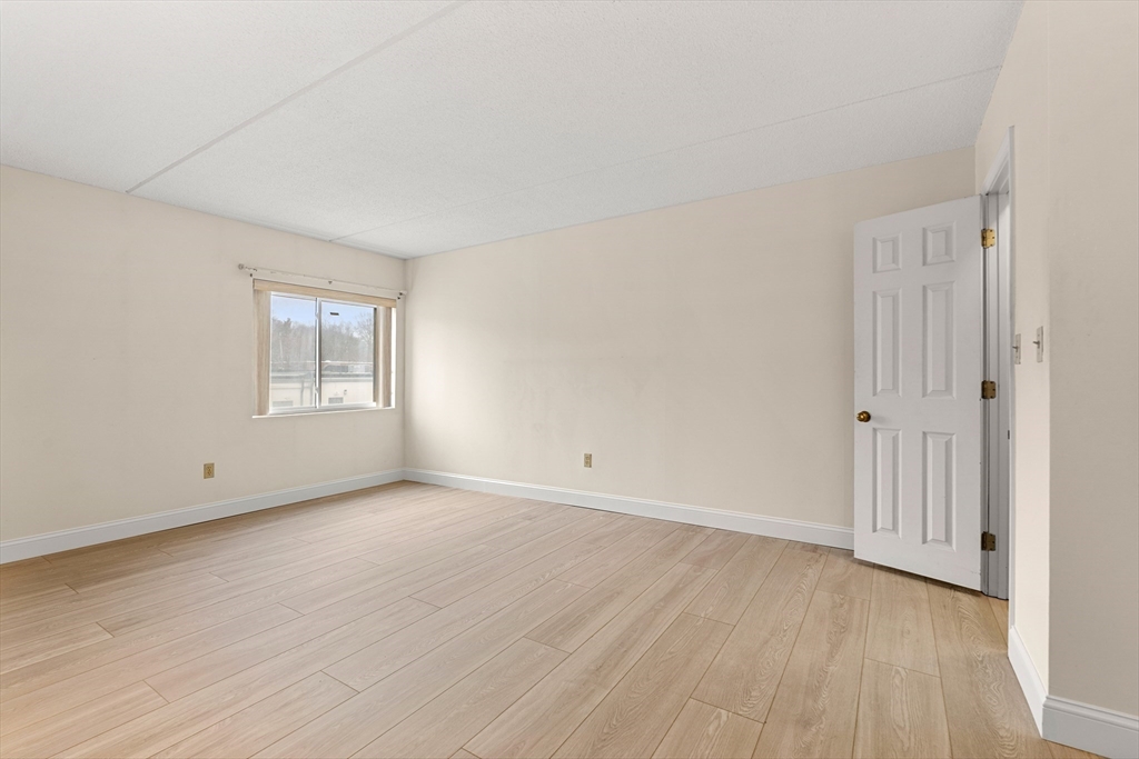 159 Main Street, Unit 11B Melrose, MA 02176 - Photo 5 of 33 a view of an empty room with wooden floor and a window