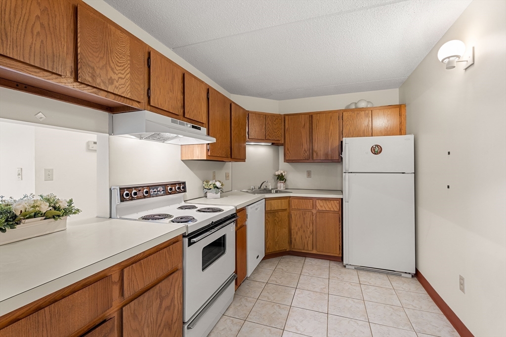 159 Main Street, Unit 11B Melrose, MA 02176 - Photo 6 of 33 a kitchen with a sink a refrigerator and cabinets