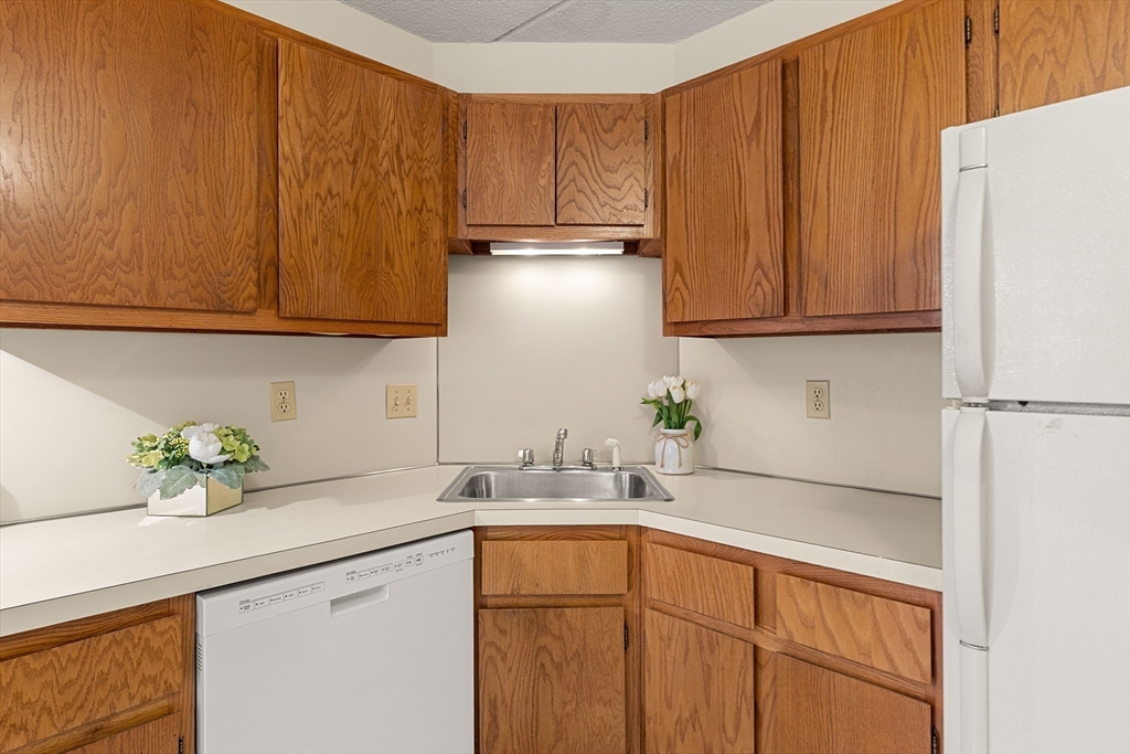 159 Main Street, Unit 11B Melrose, MA 02176 - Photo 7 of 33 a kitchen with stainless steel appliances granite countertop a sink a refrigerator and a cabinets