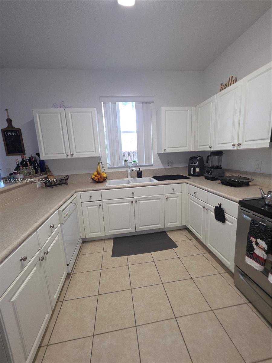 13236 Southwest 128th Street Miami, FL 33186 - Photo 12 of 41 a kitchen with a sink a stove and cabinets