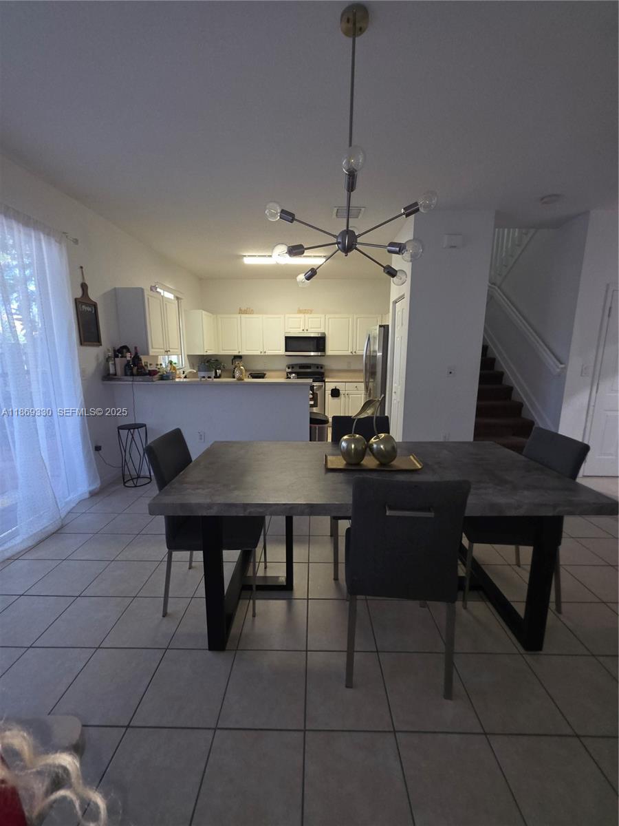 13236 Southwest 128th Street Miami, FL 33186 - Photo 14 of 41 a view of a kitchen with a dining table and chairs