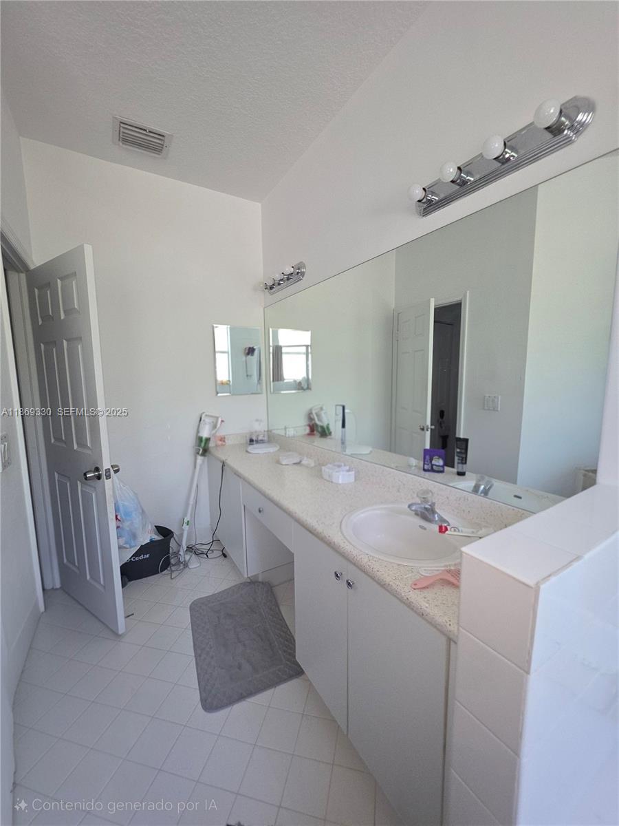 13236 Southwest 128th Street Miami, FL 33186 - Photo 22 of 41 a bathroom with a double vanity sink a mirror and a bathtub