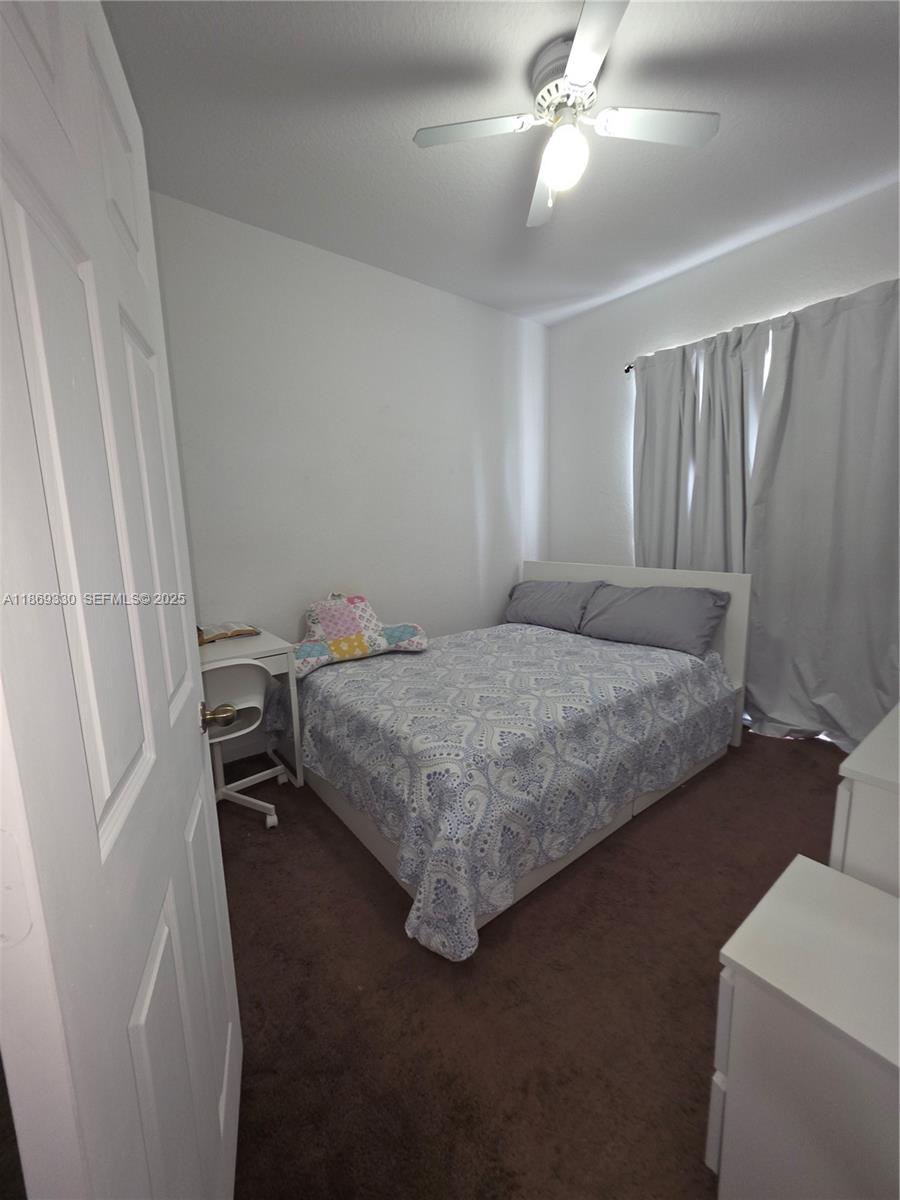 13236 Southwest 128th Street Miami, FL 33186 - Photo 24 of 41 a bedroom with a bed and a chandelier