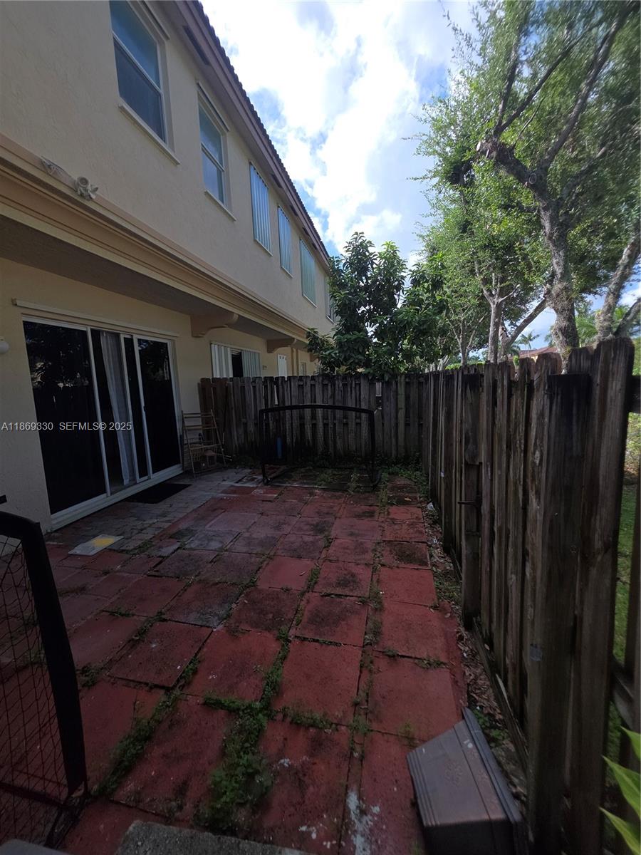 13236 Southwest 128th Street Miami, FL 33186 - Photo 34 of 41 a view of backyard with potted plants and wooden fence