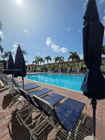 a view of a brick house with a large windows and a flower garden