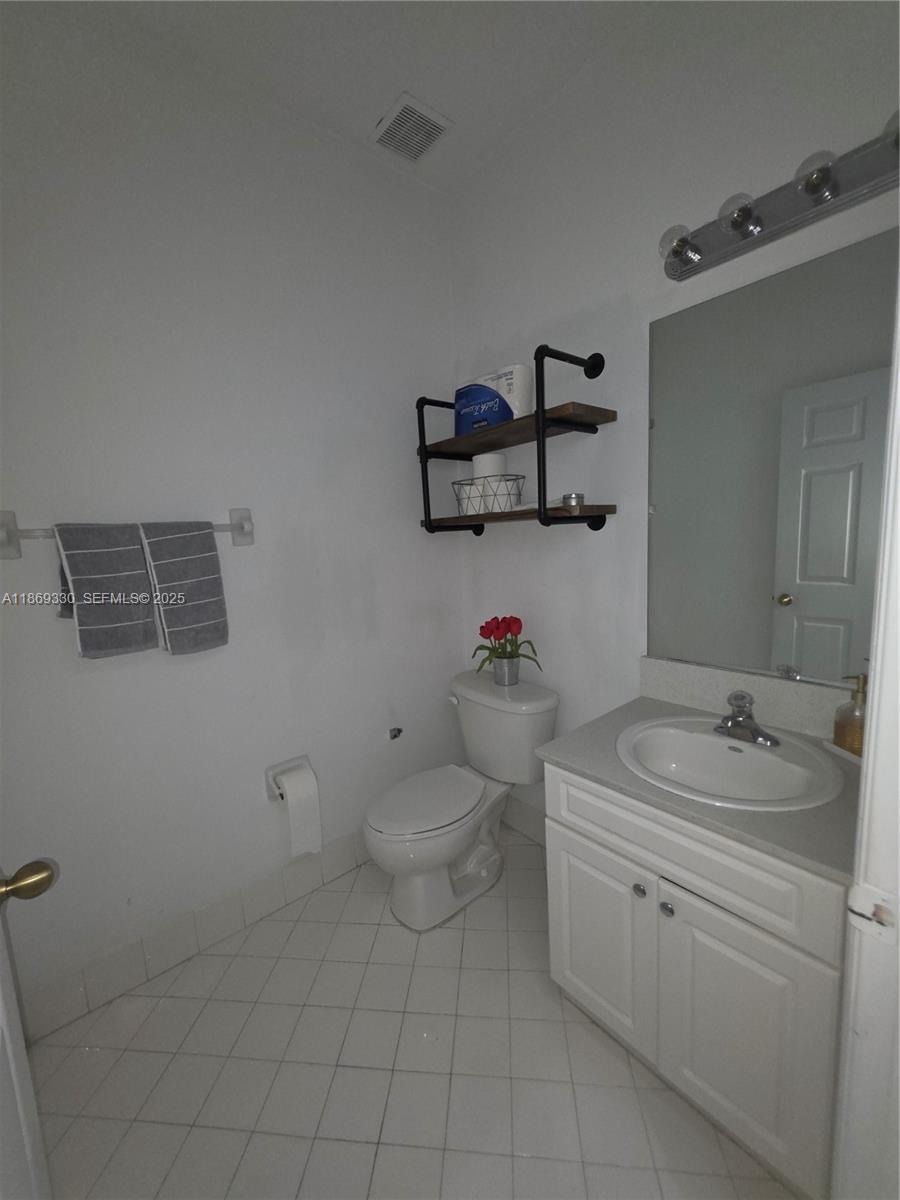 13236 Southwest 128th Street Miami, FL 33186 - Photo 7 of 41 a bathroom with a granite countertop toilet and sink