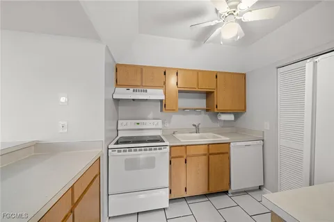 a kitchen with a sink a stove and cabinets