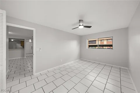 a view of an empty room and chandelier fan