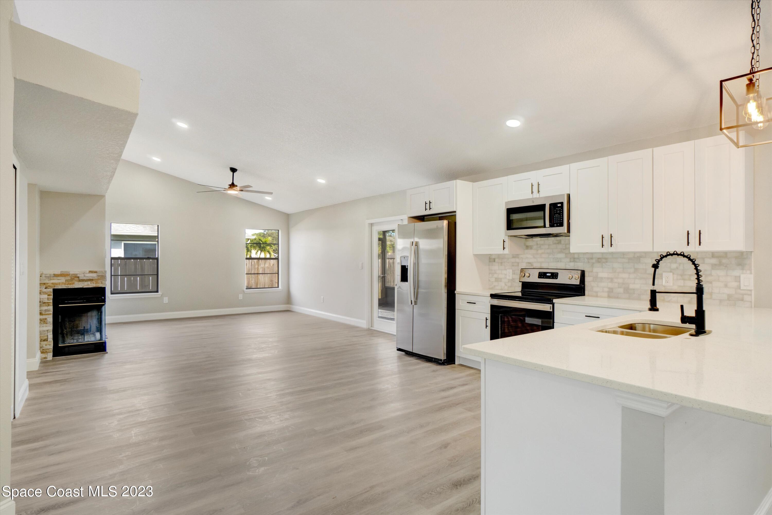 207 Eldron Boulevard Southeast Palm Bay, FL 32909 - Photo 13 of 60 a kitchen with stainless steel appliances a refrigerator microwave and sink
