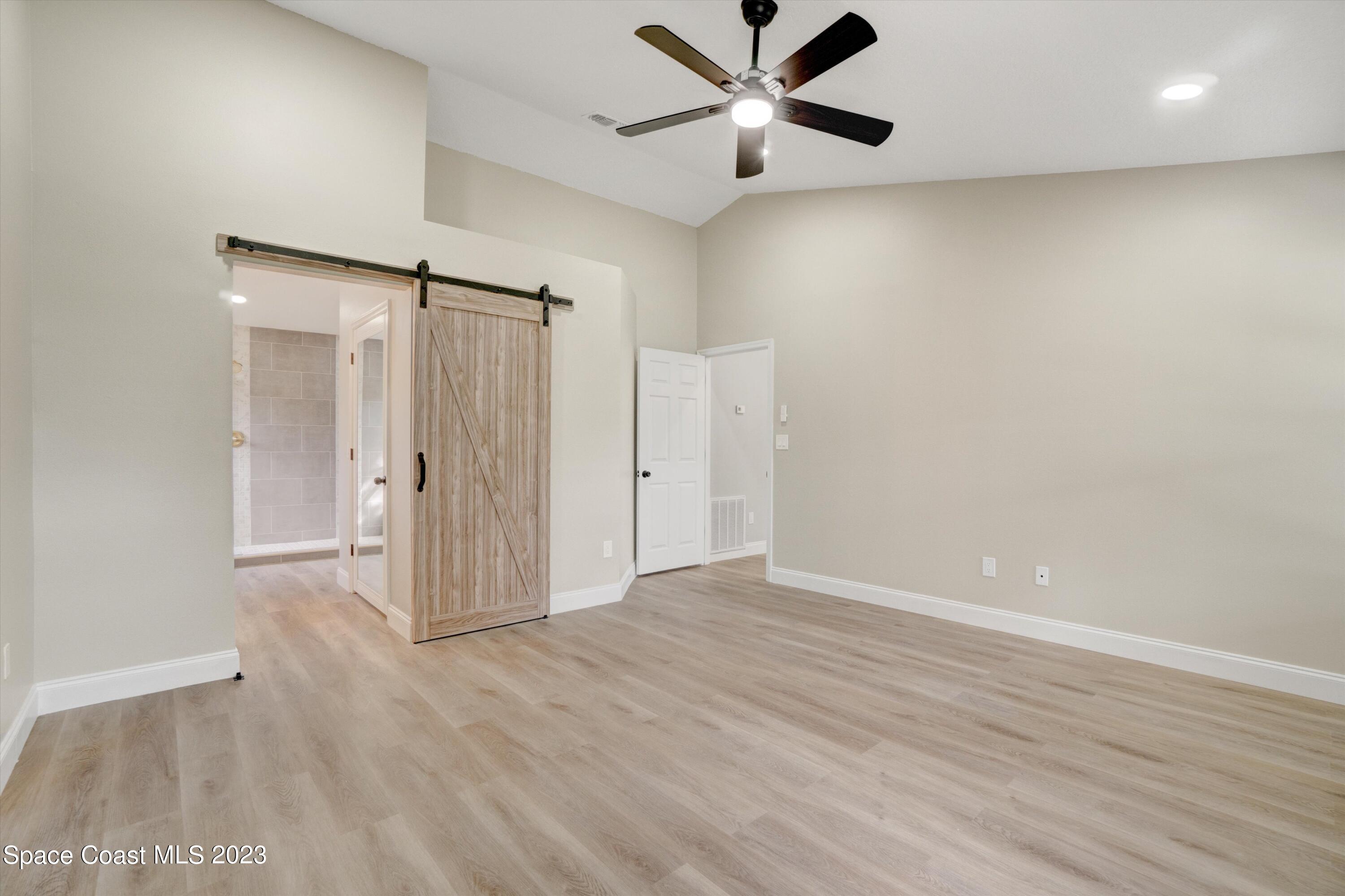 207 Eldron Boulevard Southeast Palm Bay, FL 32909 - Photo 25 of 60 an empty room with wooden floor fan and windows