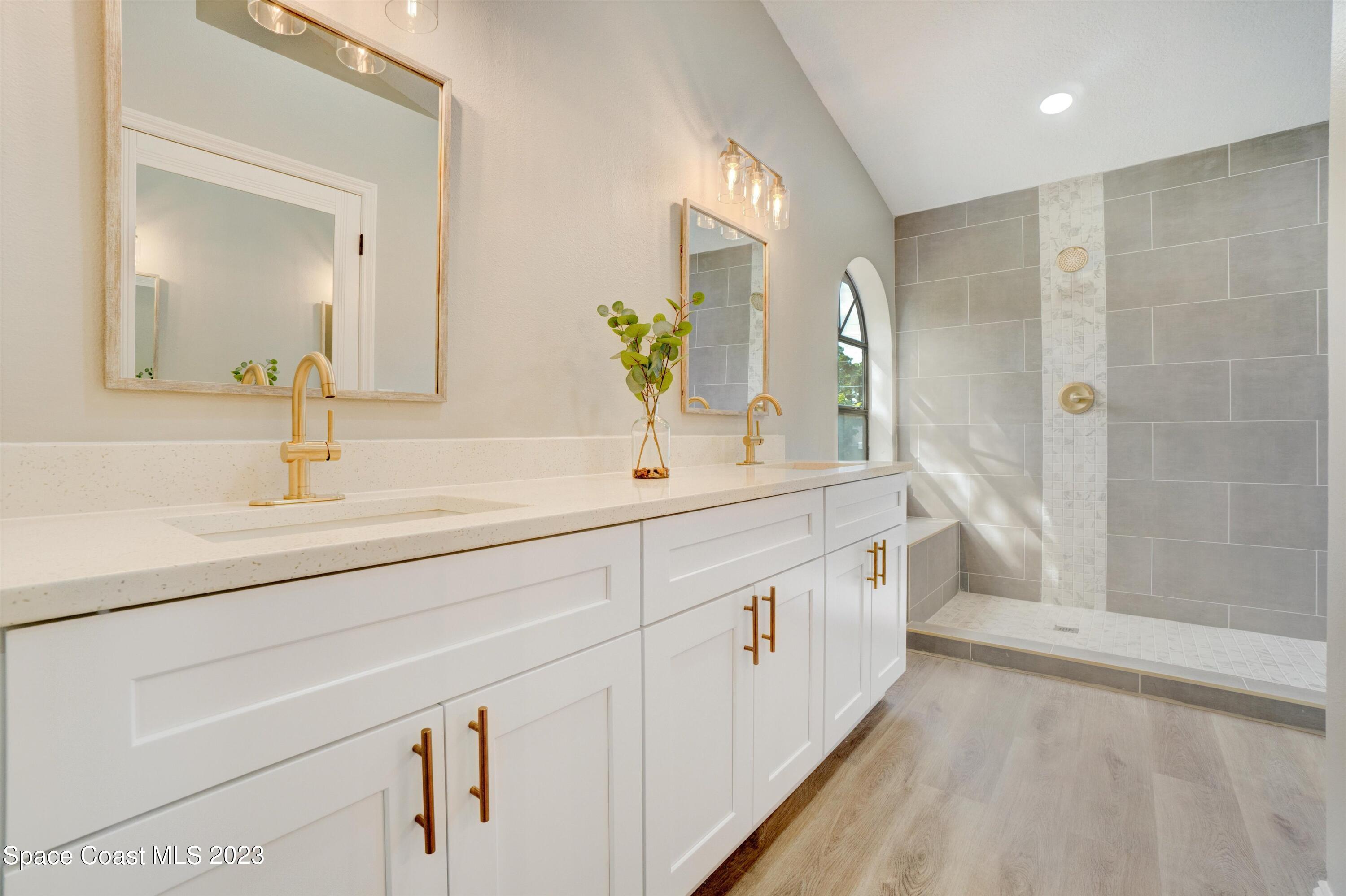 207 Eldron Boulevard Southeast Palm Bay, FL 32909 - Photo 27 of 60 a spacious bathroom with double vanity and a mirror