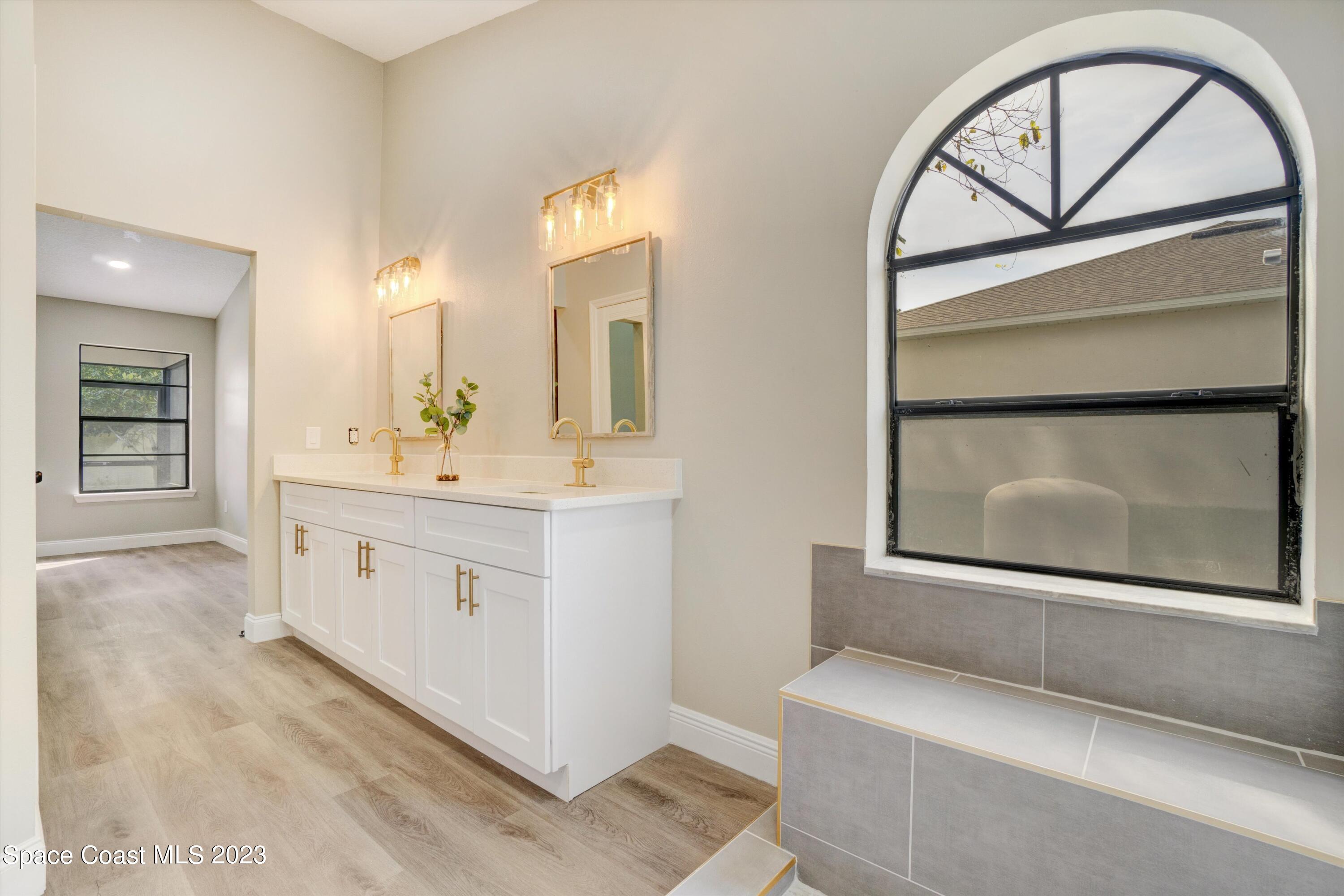 207 Eldron Boulevard Southeast Palm Bay, FL 32909 - Photo 29 of 60 a bathroom with a double vanity sink and mirror