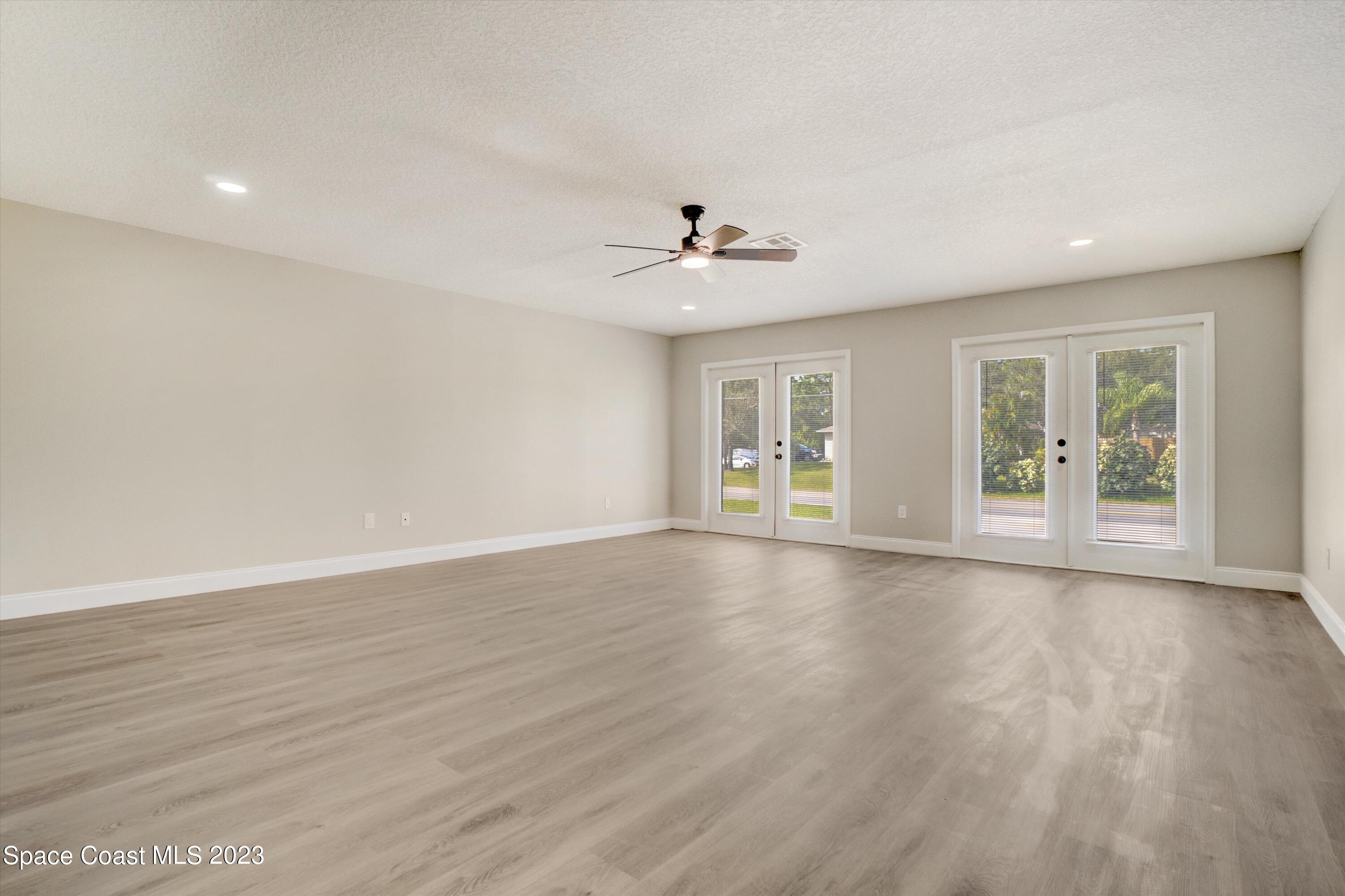 207 Eldron Boulevard Southeast Palm Bay, FL 32909 - Photo 31 of 60 a view of an empty room with a window and wooden floor