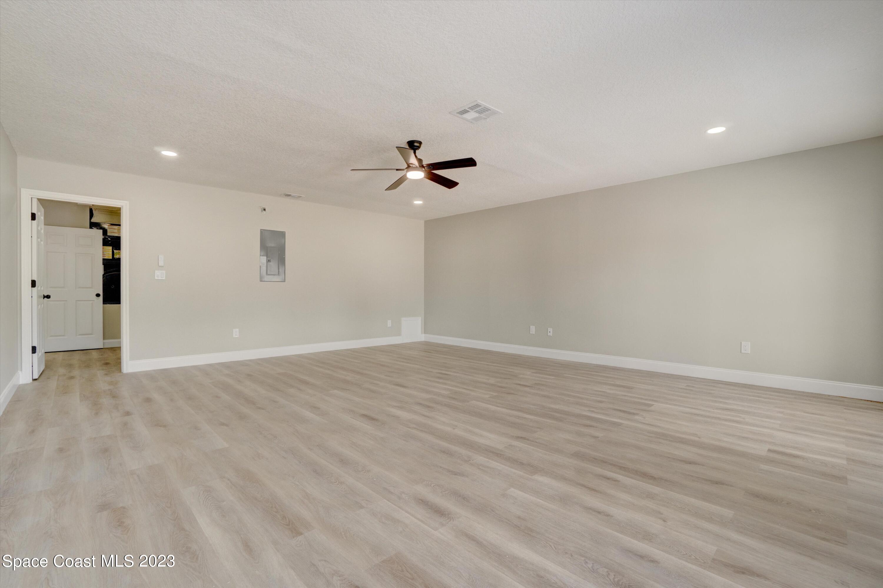 207 Eldron Boulevard Southeast Palm Bay, FL 32909 - Photo 33 of 60 wooden floor in an empty room with a ceiling fan