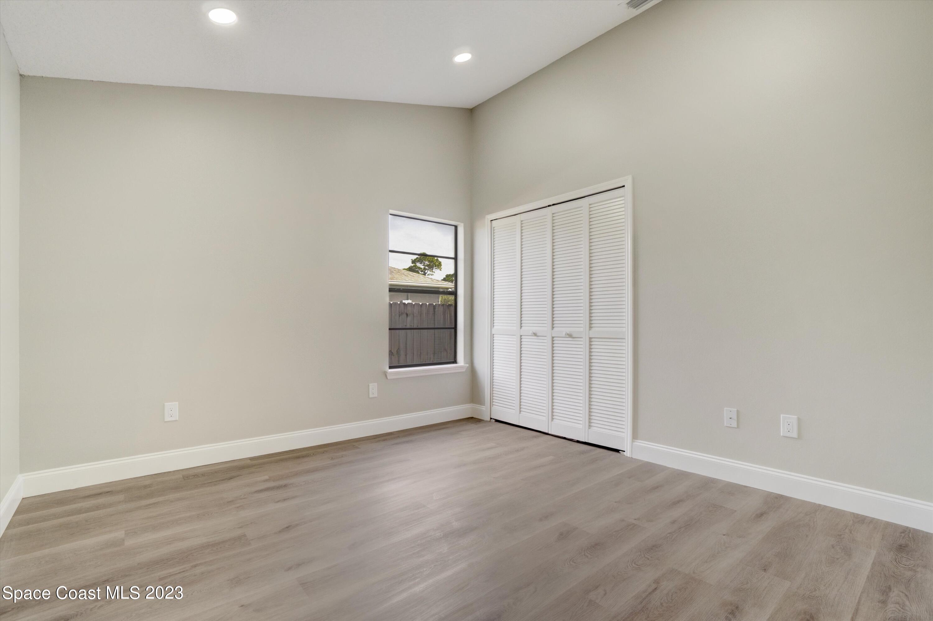 207 Eldron Boulevard Southeast Palm Bay, FL 32909 - Photo 36 of 60 an empty room with wooden floor and windows