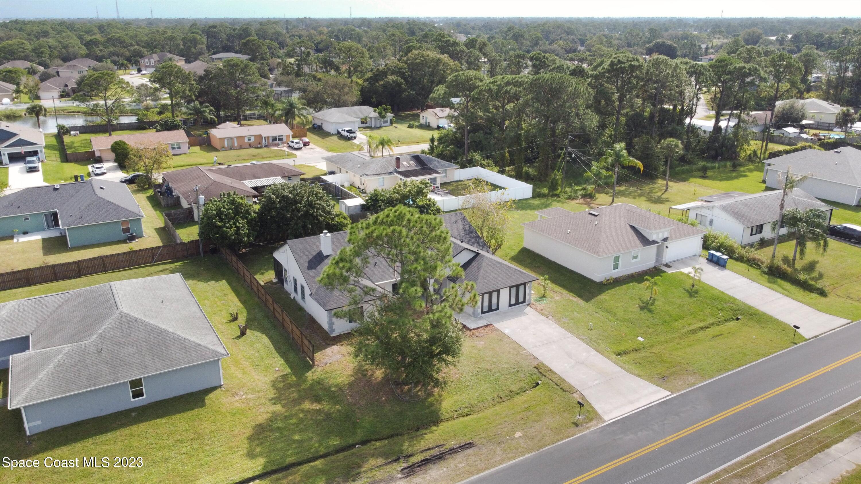 207 Eldron Boulevard Southeast Palm Bay, FL 32909 - Photo 50 of 60 an aerial view of a house with a garden and lake view