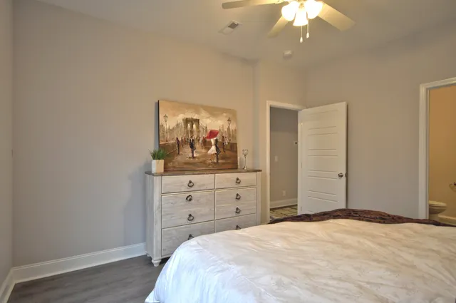 a bed sitting in a bedroom next to a window and a chandelier