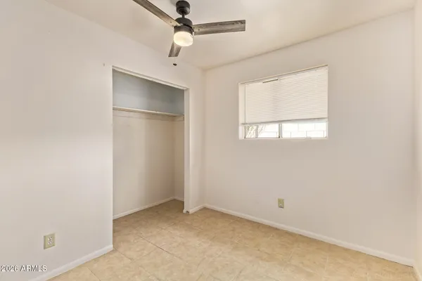 an empty room with a window and a fan