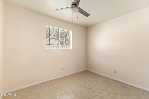 an empty room with a window and a ceiling fan