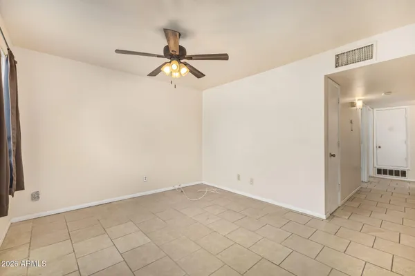 en empty room with white walls and ceiling fan